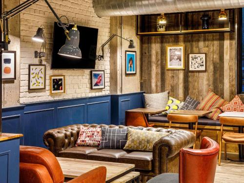a restaurant with leather couches and tables and chairs at ibis Budget Sheffield Centre St Marys Gate in Sheffield