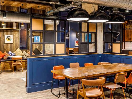a dining room with a blue wall and a table and chairs at ibis Budget Sheffield Centre St Marys Gate in Sheffield