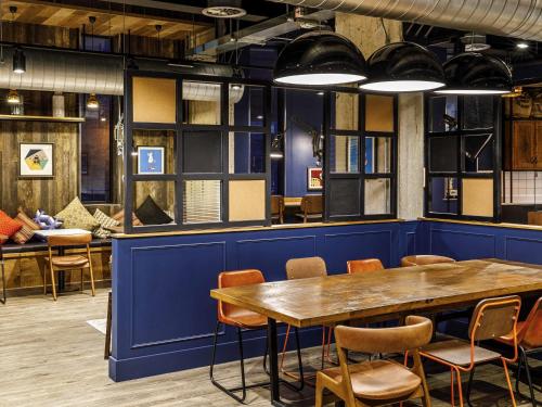 a dining room with a blue wall and a table and chairs at ibis Budget Sheffield Centre St Marys Gate in Sheffield