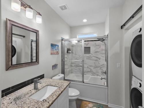 a bathroom with a shower and a toilet and a sink at Seadreamz! Beachfront Heated Salt Pool! Sleep24! in Caplen