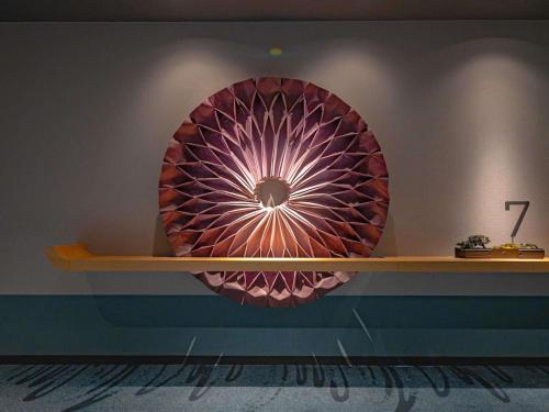 a mirror on a wall with a shelf at Mercure Kyoto Station in Kyoto