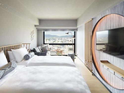 a hotel room with two beds and a large window at Mercure Kyoto Station in Kyoto