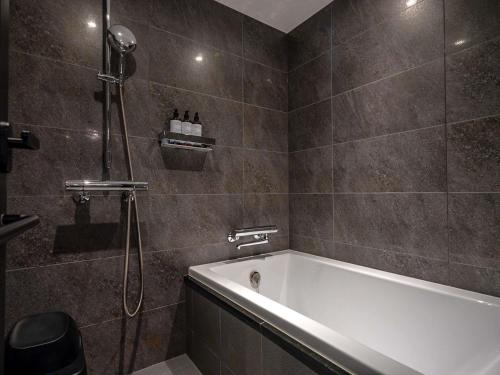 a bathroom with a bath tub and a shower at Mercure Kyoto Station in Kyoto