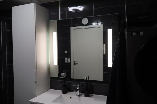 een badkamer met een wastafel en een grote spiegel bij Modern apartment on Kvaløya in Tromsø