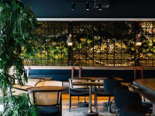 a restaurant with tables and chairs and a large window at Mercure Kyoto Station in Kyoto