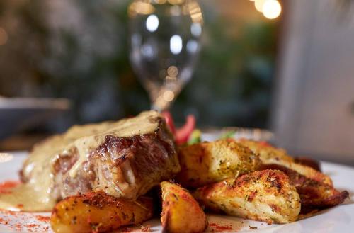 a plate of food with meat and potatoes on a table at Cyan Hotel de Las Americas in Buenos Aires