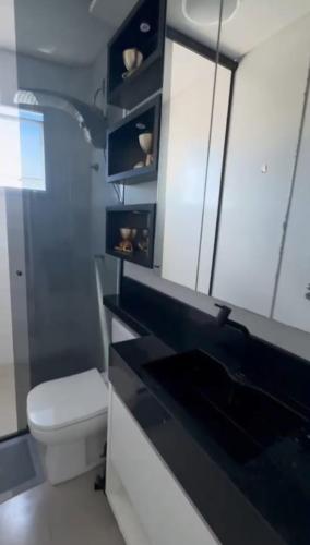 un bagno con un water e un piano di lavoro nero di Espanha Residence a Florianópolis