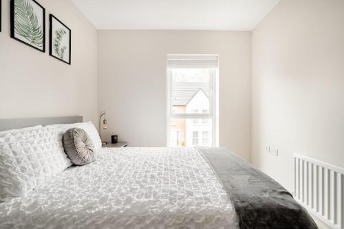 a white bedroom with a large bed and a window at Double Room in Luxury High Trees Development in Donaghadee