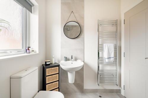 a white bathroom with a sink and a mirror at Double Room in Luxury High Trees Development in Donaghadee