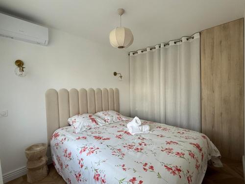 Un dormitorio con una cama con flores rojas. en Le Ptit Cocon Disneyland 10 min, en Coupvray