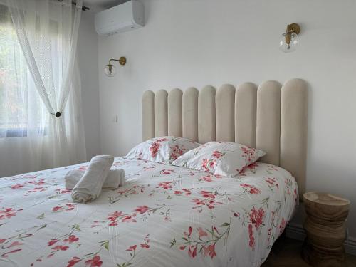 a bedroom with a large white bed with red flowers at Le Ptit Cocon Disneyland 10 min in Coupvray