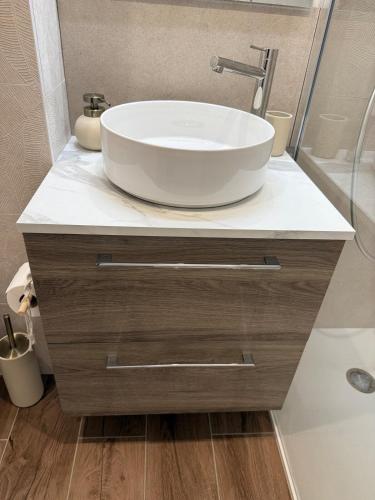 a bathroom with a white sink and a tub at Le Ptit Cocon Disneyland 10 min in Coupvray