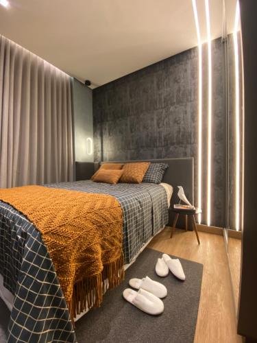a bedroom with a bed with white shoes on the floor at Anmu experiencie in Montes Claros
