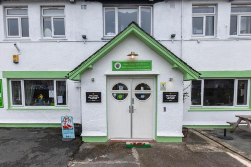 a white and green building with a door at Ty glyndwr Hotel in Bangor