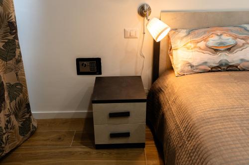 a bedroom with a bed and a nightstand with a lamp at Orfeo Guest House in Bari