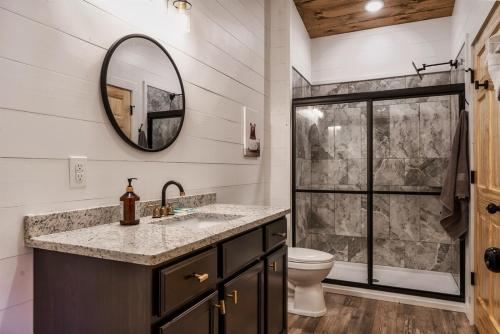 ピジョン・フォージにあるDotin' on Dolly - Charming 4BR Cabin Hot Tub,Pool,Foosball & Arcadeの洗面台、トイレ、鏡のあるバスルーム