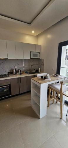 a kitchen with white cabinets and a table and chairs at Appartement t2 neuf en residence ,dakar in Dakar