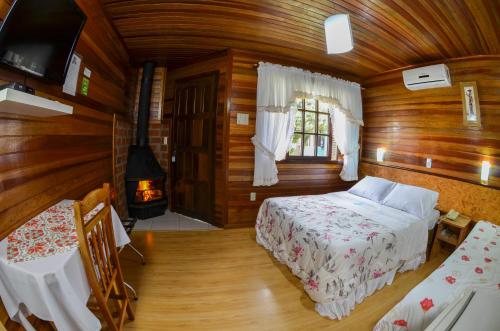 ein Schlafzimmer mit einem Bett und einem Kamin in einem Zimmer in der Unterkunft Pousada Gramadense in Gramado