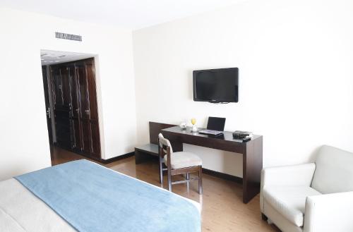 a living room with a desk and a tv at Cyan Hotel de Las Americas in Buenos Aires