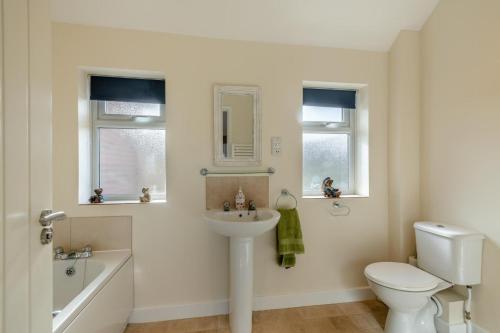 Un baño con lavabo, inodoro y bañera. en Little Bunting, en Heacham