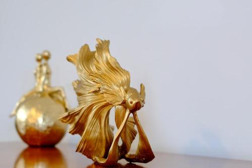 a gold flower on a table next to a bottle at Le nid de l'Oison - Magnifique duplex pour 2 in La Celle-sous-Gouzon