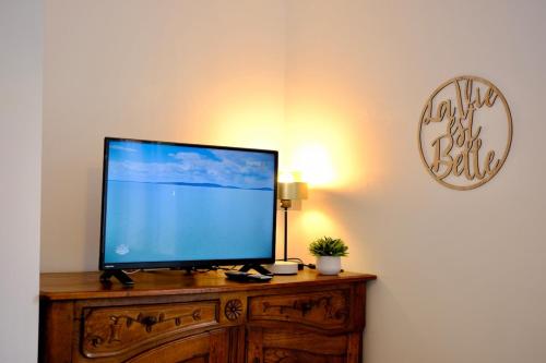 a flat screen tv sitting on top of a wooden dresser at Le nid de l'Oison - Magnifique duplex pour 2 in La Celle-sous-Gouzon