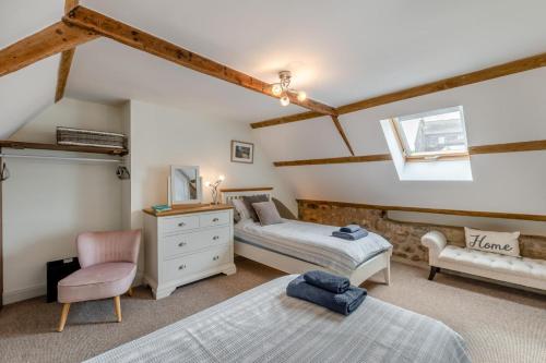 a bedroom with two beds and a chair at Eastgate House Alnwick in Alnwick