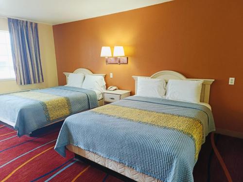 a hotel room with two beds with blue and yellow sheets at Heights Inn by Townhouse Harker Heights, TX in Harker Heights