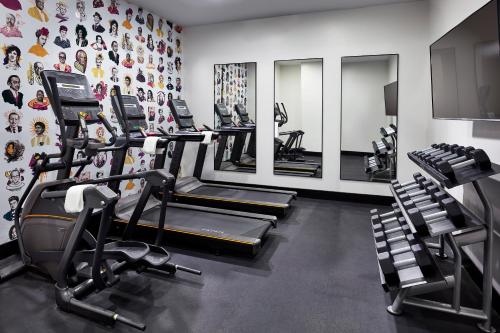 a gym with several tread machines and mirrors at Elan Hotel in Los Angeles