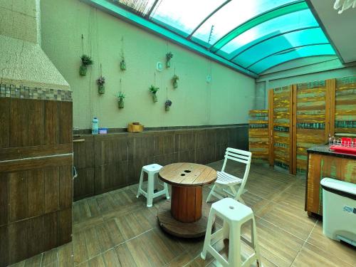 a room with a table and two stools in it at Casa no Centro de Foz 2 quartos e 2 banheiros in Salto