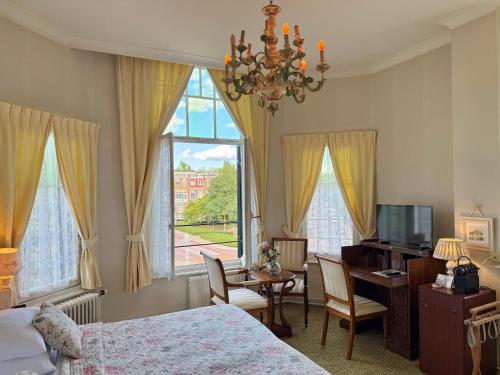 a bedroom with a bed and a desk and a window at Hotel Molendal in Arnhem