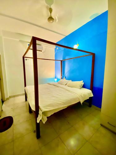 a bedroom with a canopy bed in a blue room at Villa Greek Baga 4Bhk Villa with private Pool & Kitchen in Calangute
