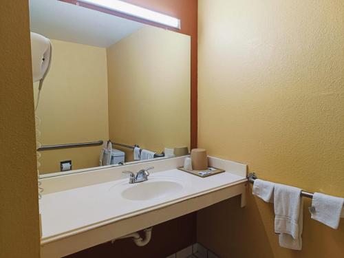a bathroom with a sink and a large mirror at Heights Inn by Townhouse Harker Heights, TX in Harker Heights