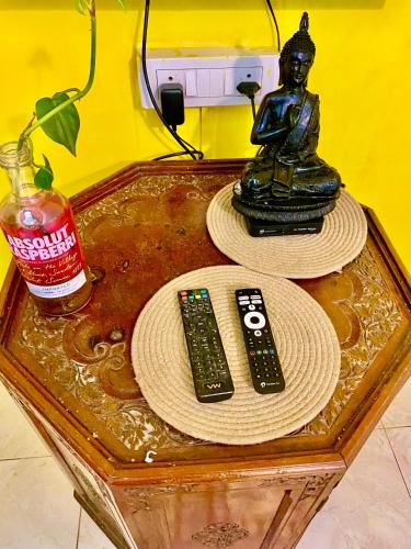 a table with two remote controls and a statue on it at Villa Greek Baga 4Bhk Villa with private Pool & Kitchen in Calangute