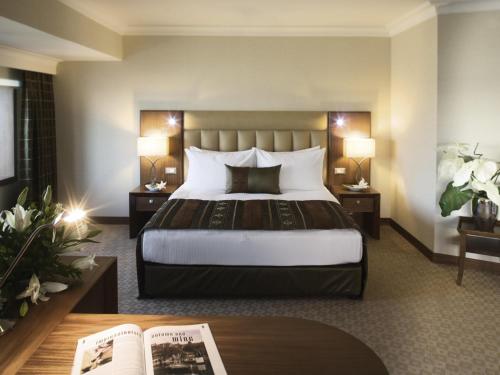 a hotel room with a large bed and a table at Mövenpick Hotel Izmir in Izmir