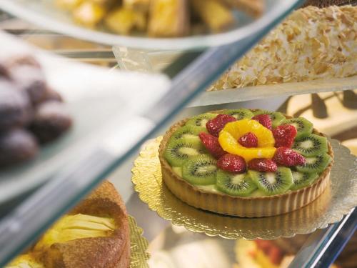 a cake with fruit on top of it on a shelf at Mövenpick Hotel Izmir in Izmir