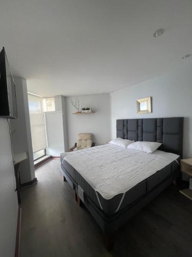Un dormitorio con una cama y un televisor de pantalla plana. en San Alfonso Del Mar, Algarrobo, en Algarrobo