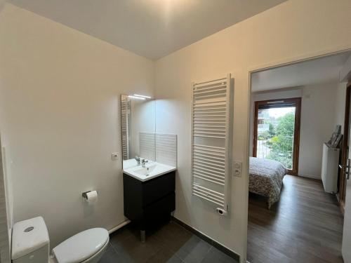 a bathroom with a sink and a toilet and a bed at Cozy appartement moderne proche Paris & Aéroport d'Orly au pied du metro 14 in Chevilly-Larue