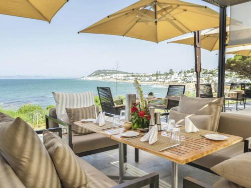 a dining room with a table and chairs and the ocean at Mövenpick Hotel Gammarth Tunis in Gammarth