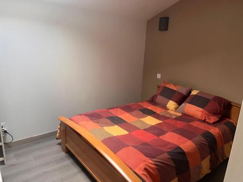 a bedroom with a bed with a checkered blanket at Gîte Appartement à la campagne in Lautrec