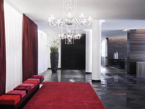 a lobby with a red carpet and a chandelier at Mövenpick Hotel Stuttgart Airport in Stuttgart