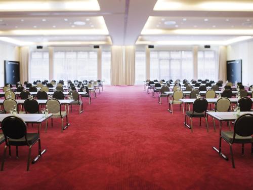 a large room with tables and chairs in it at Mövenpick Hotel Stuttgart Airport in Stuttgart
