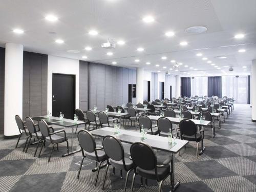 a large room with tables and chairs in it at Mövenpick Hotel Stuttgart Airport in Stuttgart