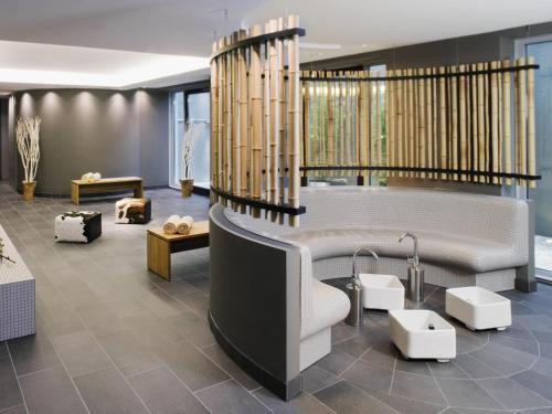 a living room with a couch and a table at Mövenpick Hotel Stuttgart Airport in Stuttgart