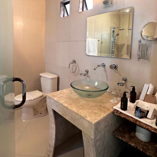 a bathroom with a sink and a toilet at Matices Hotel de Barricas in Tequila