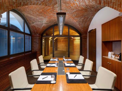 a conference room with a long table and chairs at Mövenpick Hotel Hamburg City in Hamburg