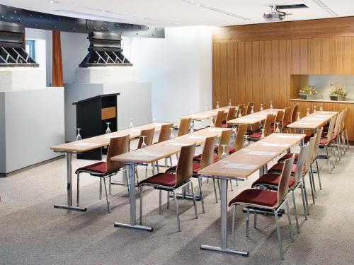 a row of tables and chairs in a room at Mövenpick Hotel Hamburg City in Hamburg