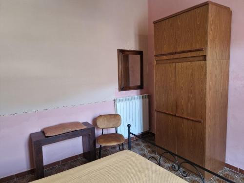 a bedroom with a bed and a chair and a dresser at Alla Fonte in Massa dʼAlbe