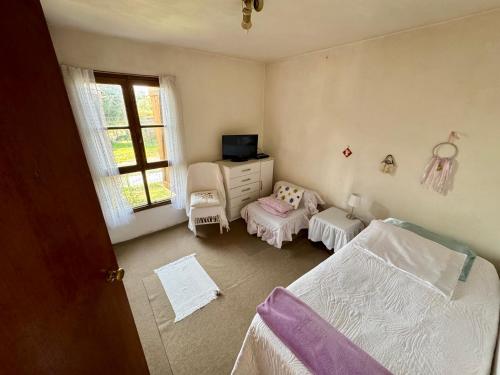 a bedroom with a bed and a tv and a dresser at Hermosa Casa familiar de 2 pisos con patio amplio in Ciudad de la Costa