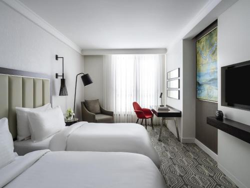 una camera d'albergo con due letti e una televisione di Mövenpick Istanbul Hotel Golden Horn a Istanbul